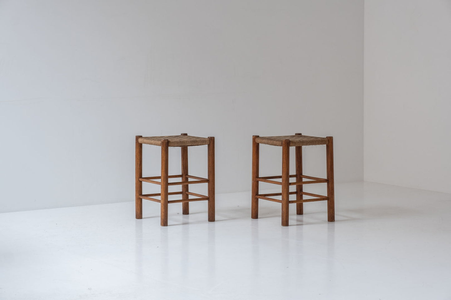 A charming set of two stools with papercord seats, crafted in France during the 1960s.